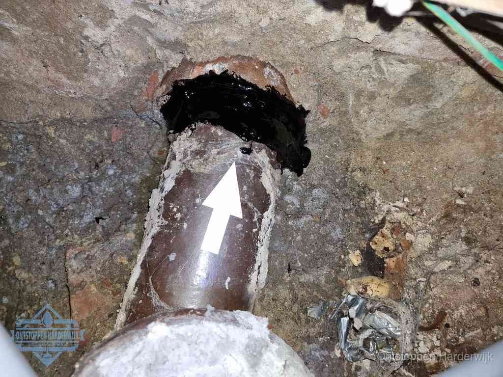 Een oude gres rioolbuis met een beschadigde koppeling onder de vloer, oorzaak van terugkerende structurele wc-problemen in Harderwijk