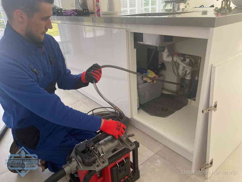 Een monteur reinigt de keukenafvoer grondig met een veermachine om terugkerende gootsteenverstoppingen te voorkomen in Harderwijk