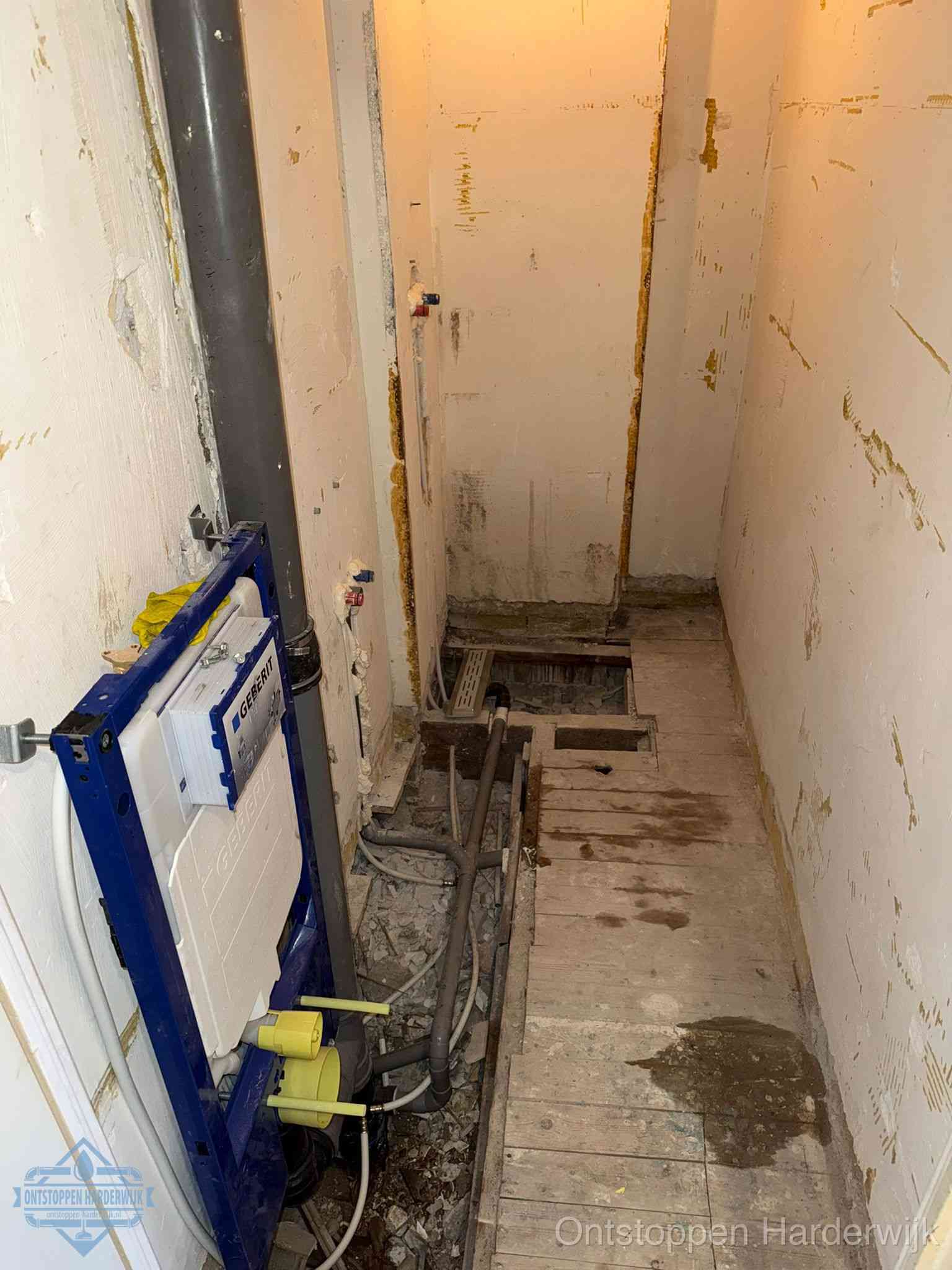 Een opgebroken toiletruimte tijdens renovatie met een Geberit inbouwreservoir en blootliggende oude afvoerleidingen, typisch voor oudere woningen in Harderwijk