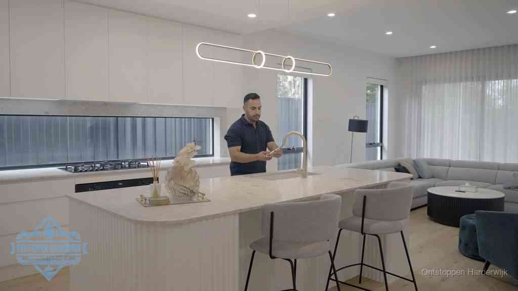 Een bewoner bij de keukenspoelbak die zelf aan de slag gaat met een verstopte gootsteen in Harderwijk